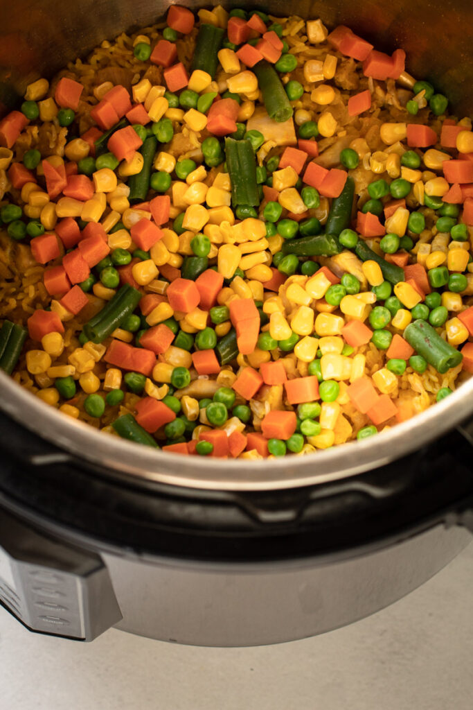 Frozen veggies in an instant pot on top of chicken and rice.