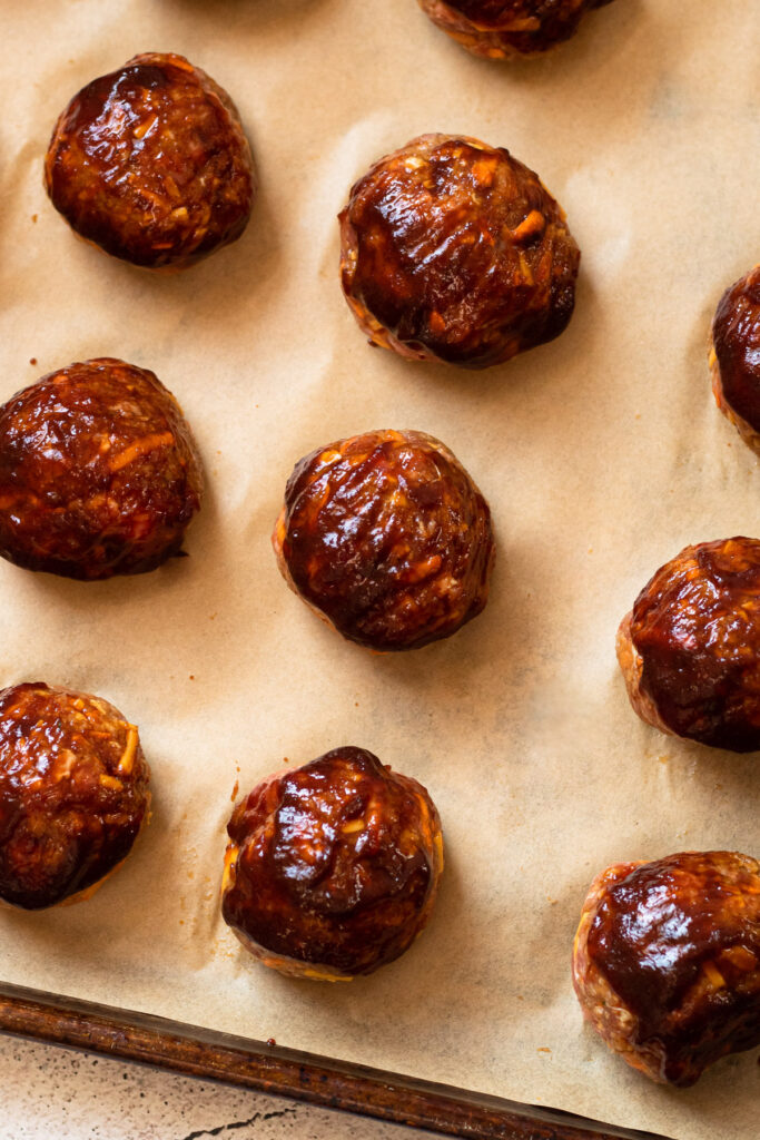 Baked bbq meatballs on a sheet pan.