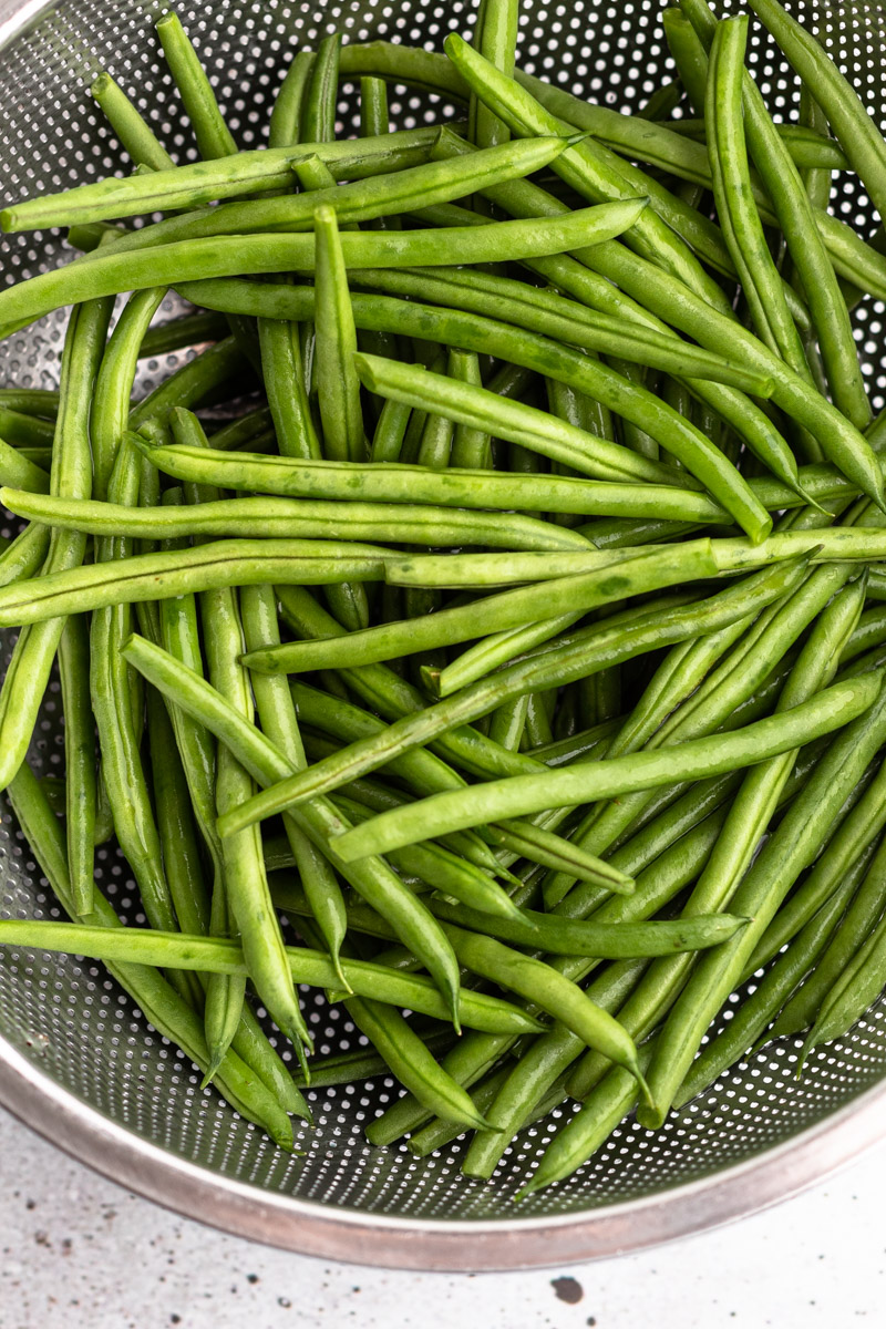 Trimmed grean beans in a strainer.