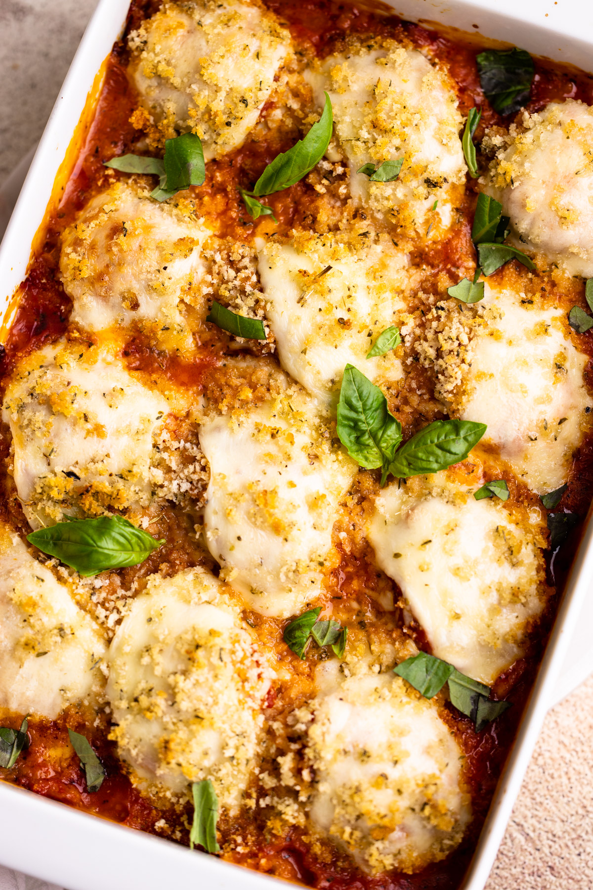 A casserole dish with chicken parmesan meatballs.