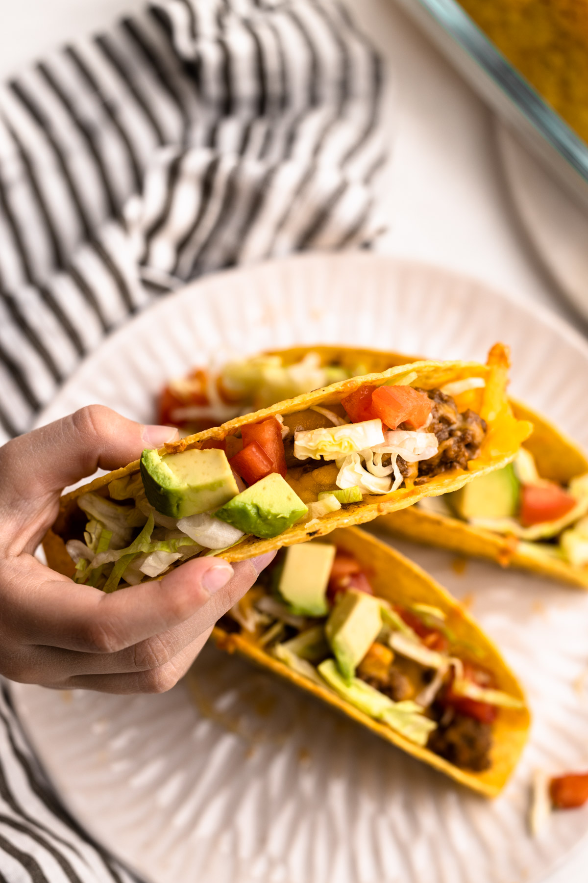 A baked beef taco served on a plate.