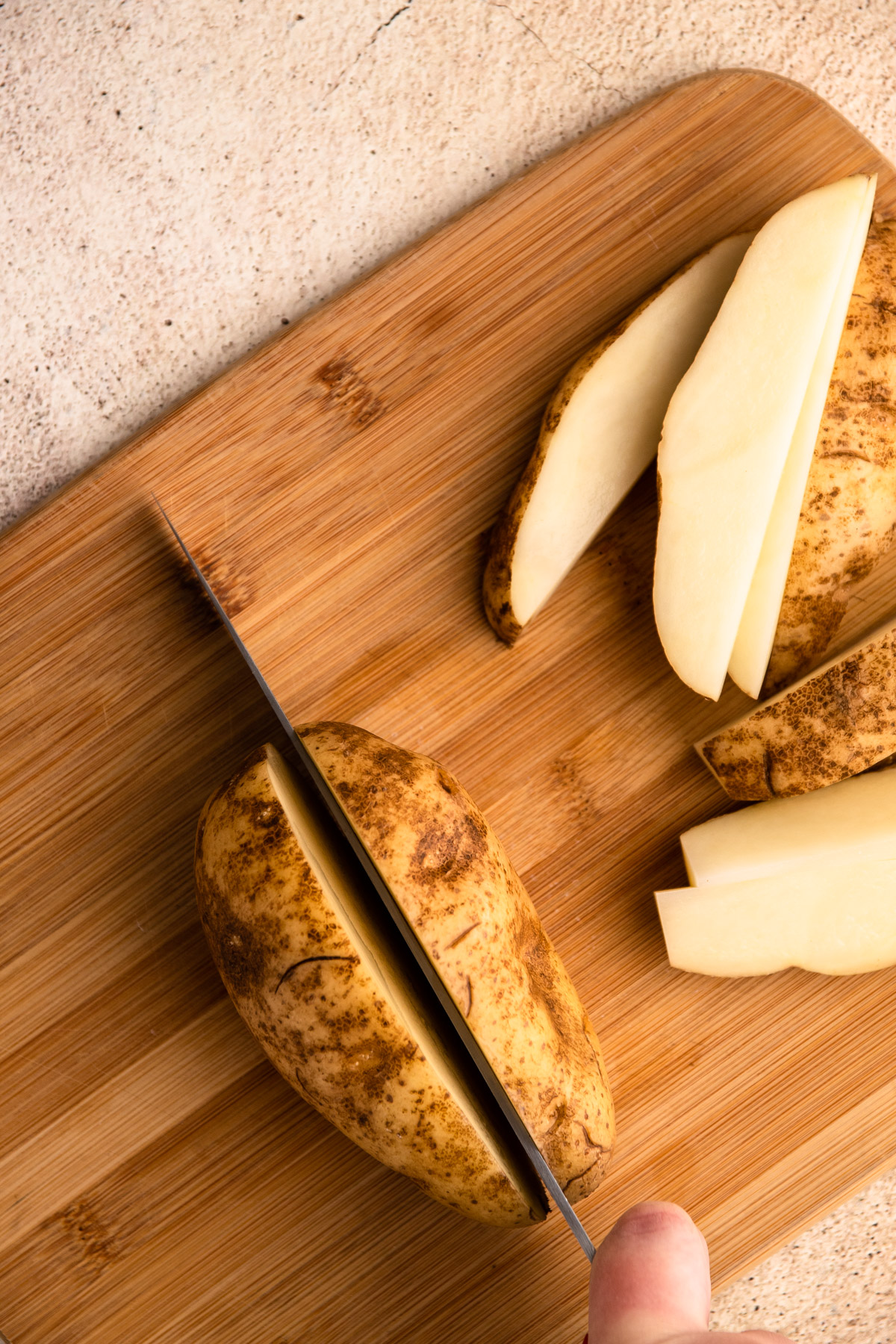 Cutting a russett potato for potato wedges.