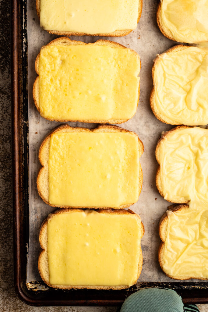 A sheet pan with melty cheese for oven baked grilled cheese.