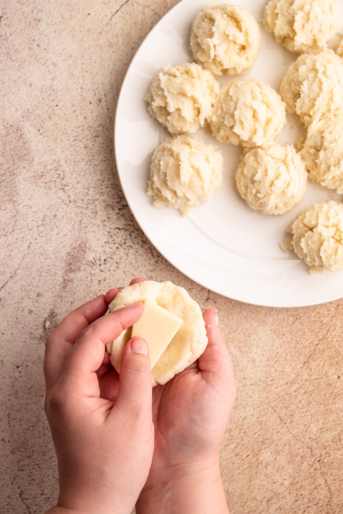 Placing cheese in arepa dough.