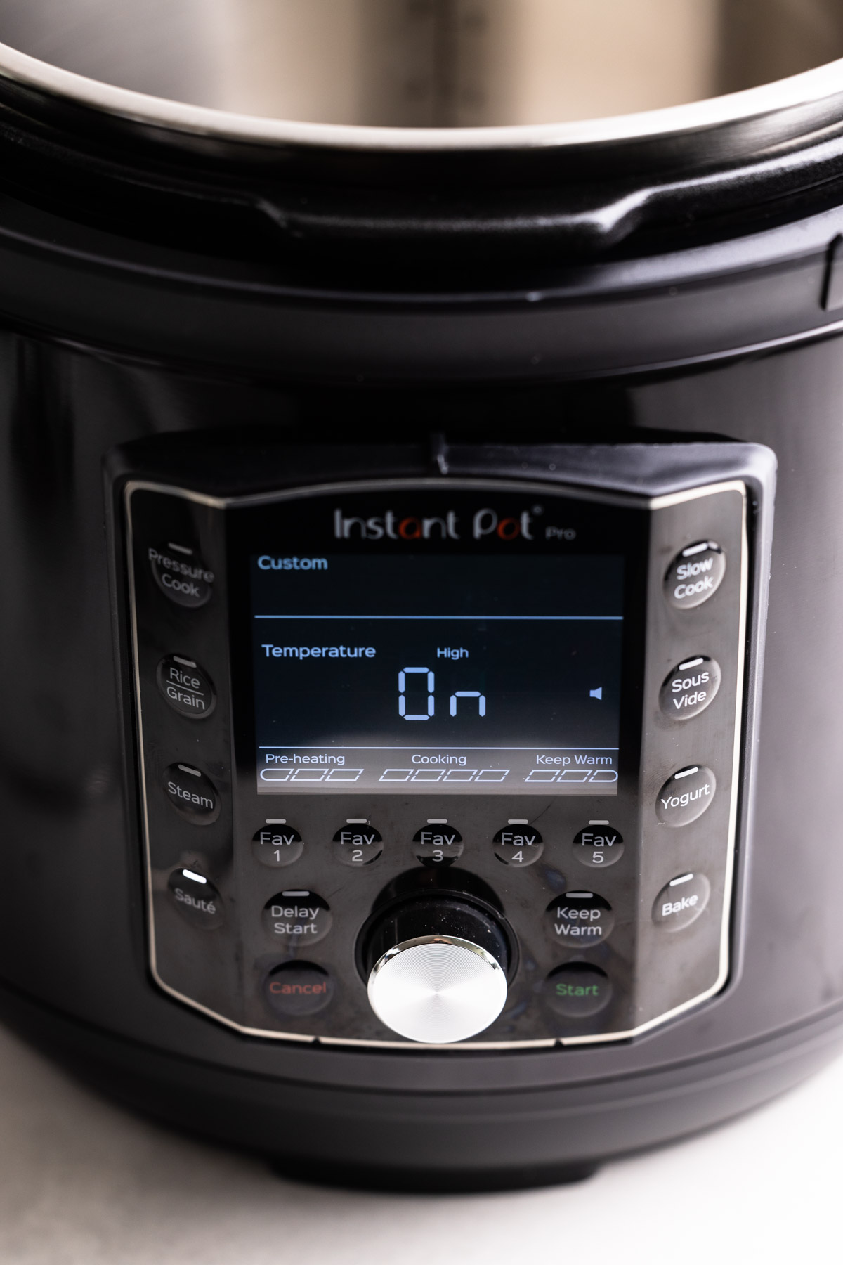 An instant pot turned on with a visible on sign.