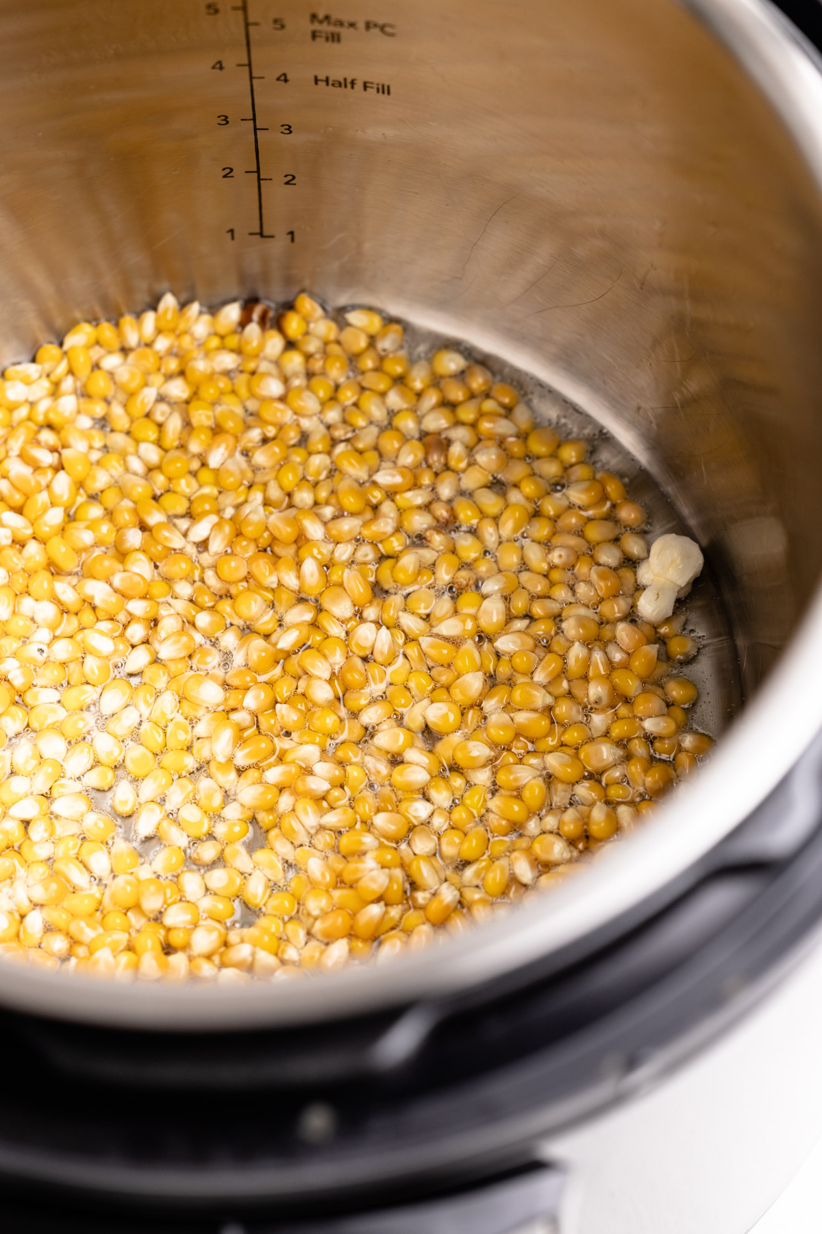 Kernels in the instant pot with one popped.