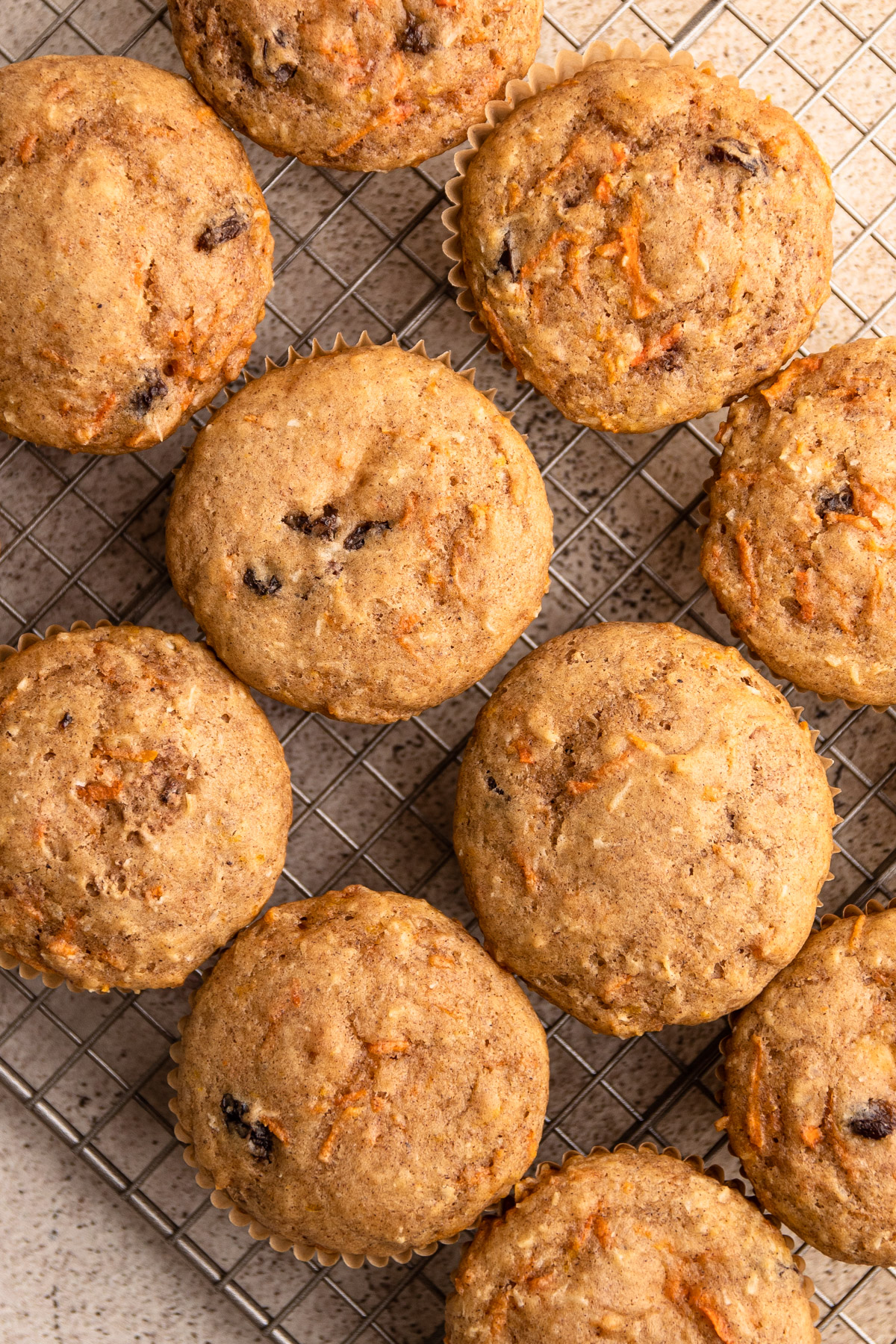 Baked carrot cake muffins on a cooling rack.