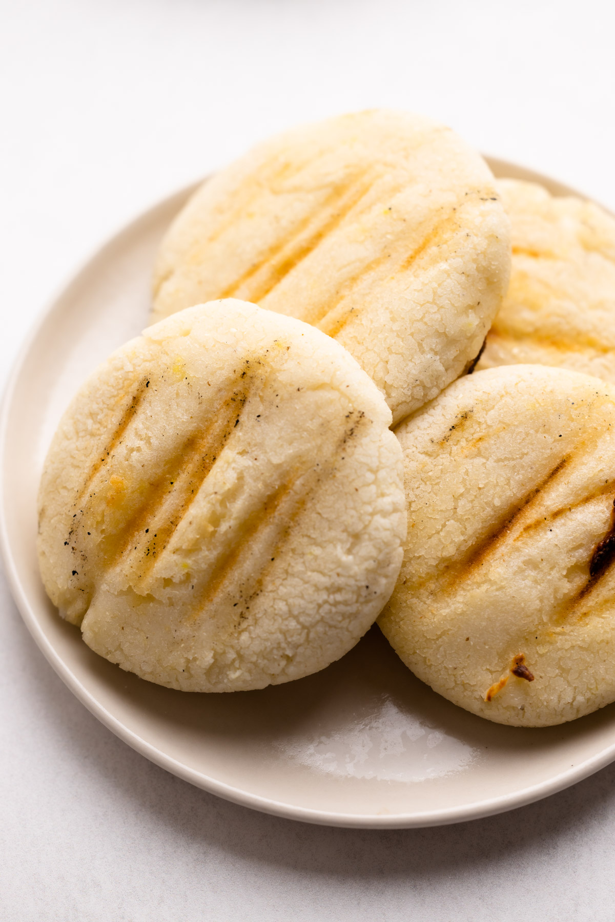 Arepas cooked on a grill pan.