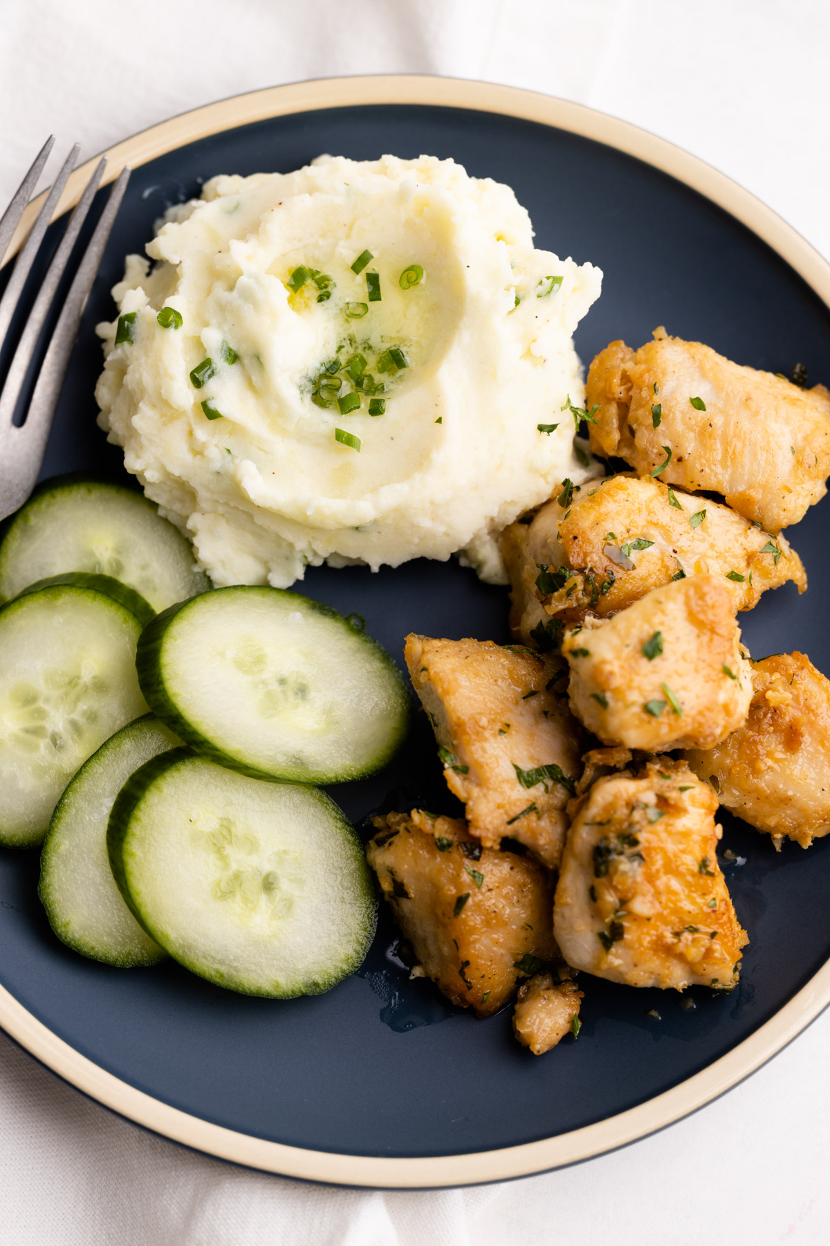 A plate of chicken with sour cream and onion mashed potatoes.