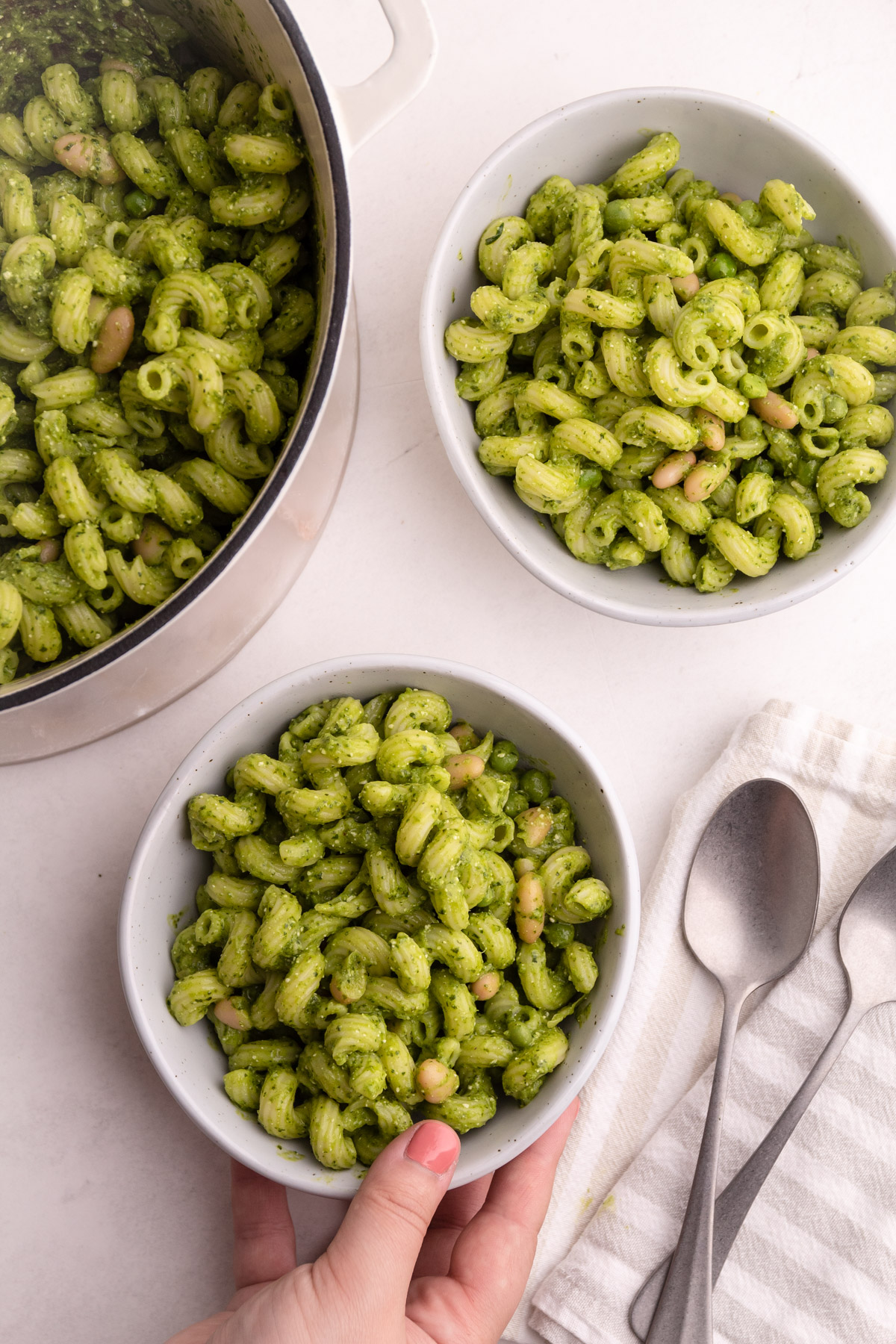 Two bowls of pesto pasta.