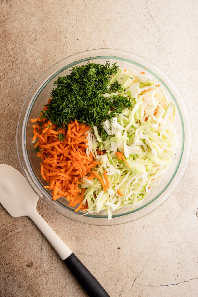 Ingredients for Cole slaw with dill in a bowl.