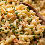 Creamy macaroni salad in a bowl with a sprinkle of parsley.