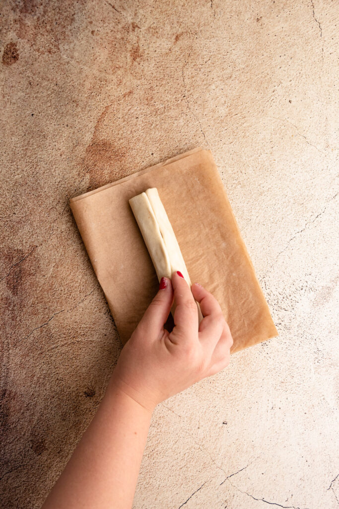 Pinching together the puff pastry seams for pigs in a blanket.