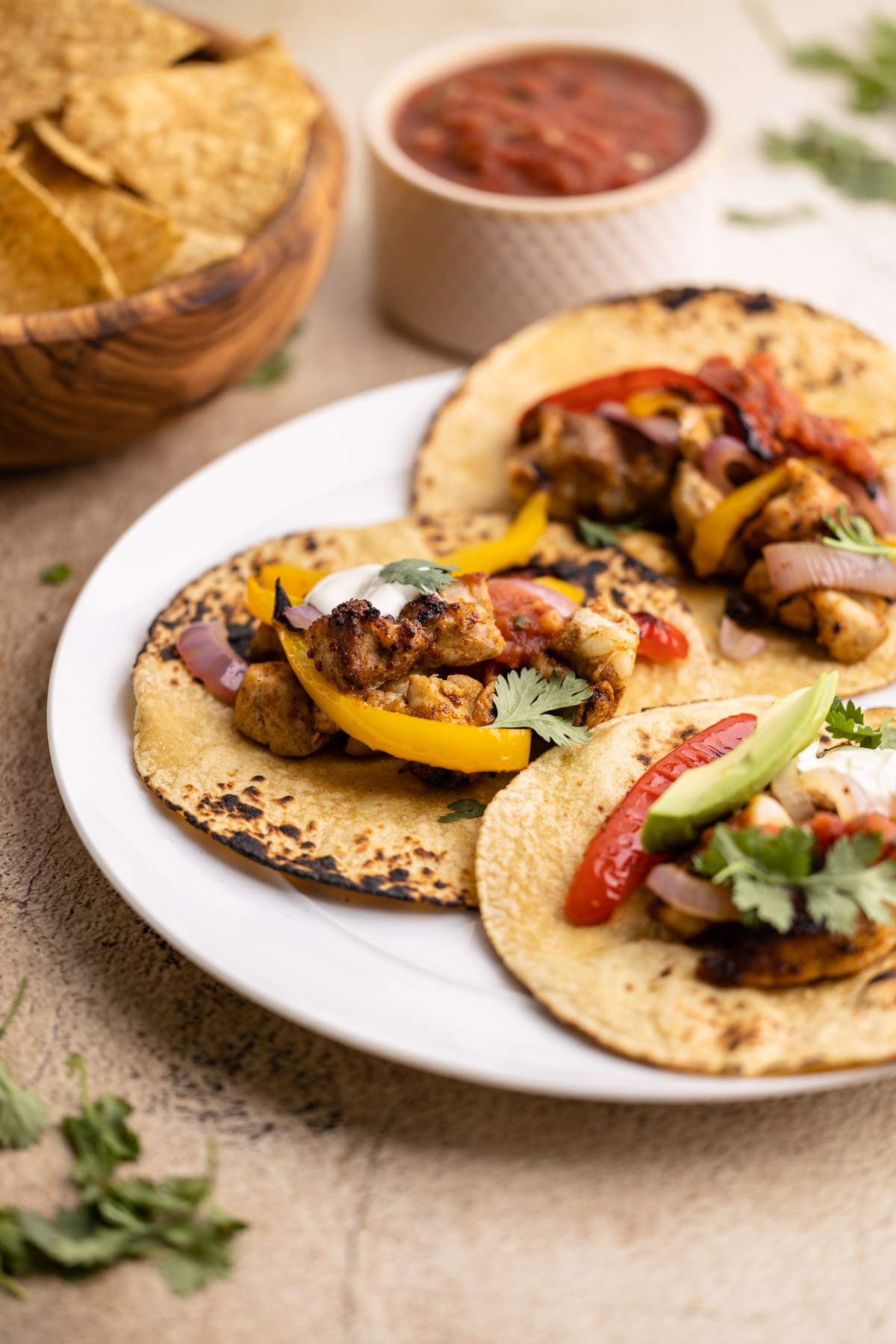 Three chicken fajitas served on a plate.