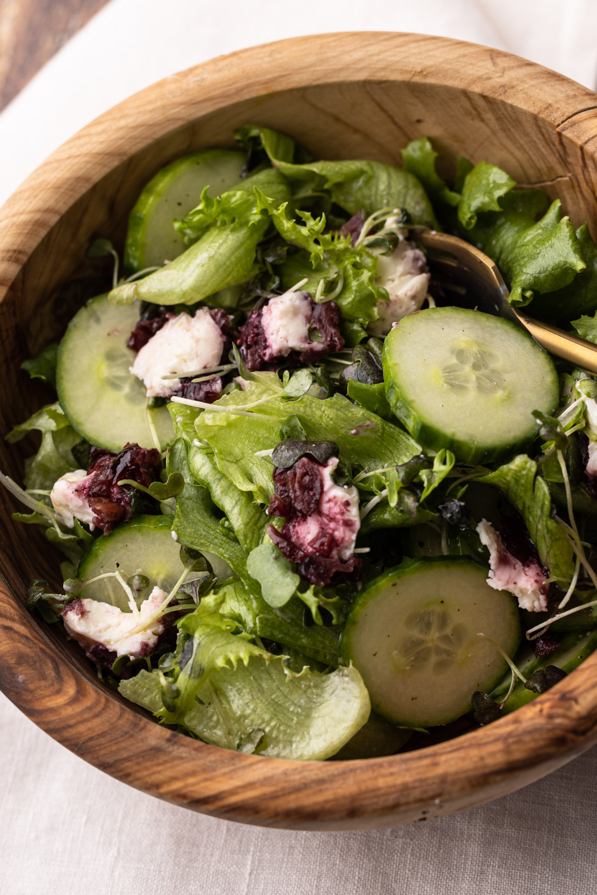 A goat cheese salad in a wooden bowl.