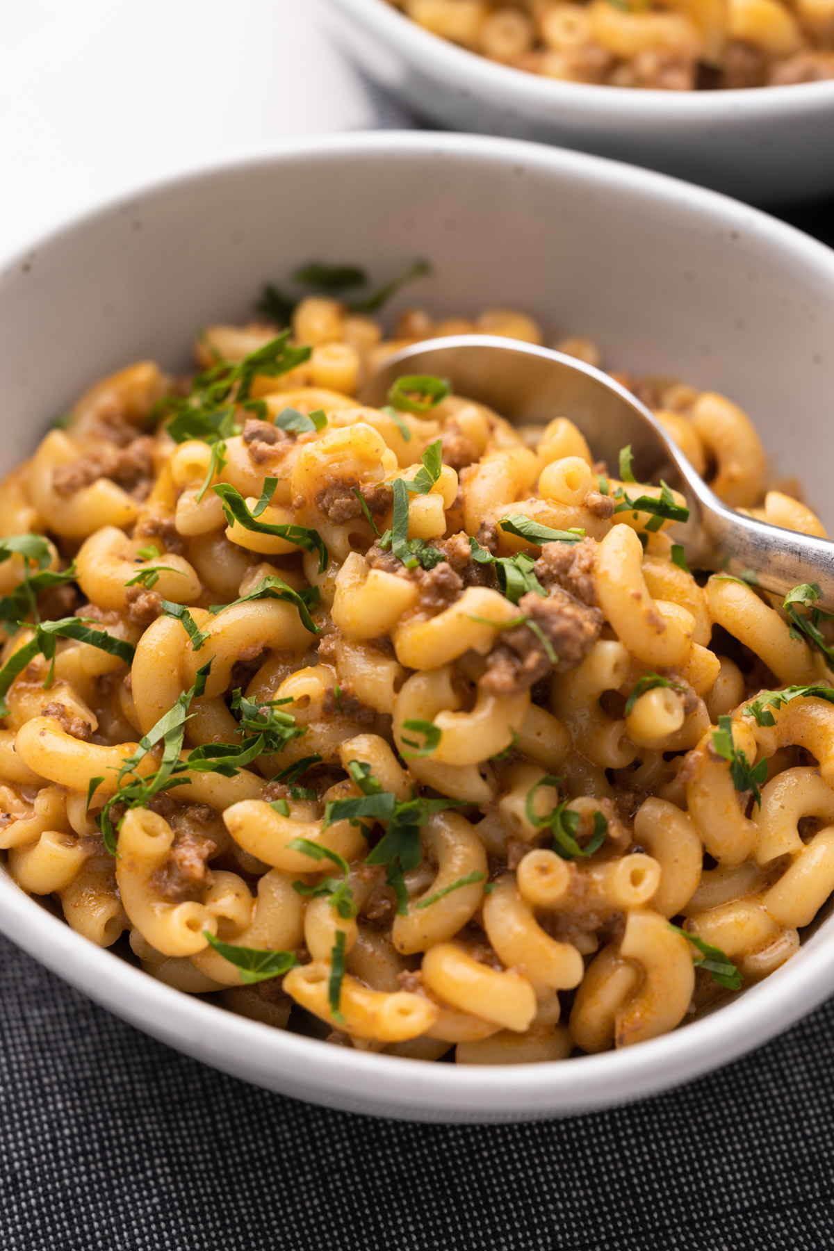 A bowl of homemade hamburger helper with parsley sprinkled on top.