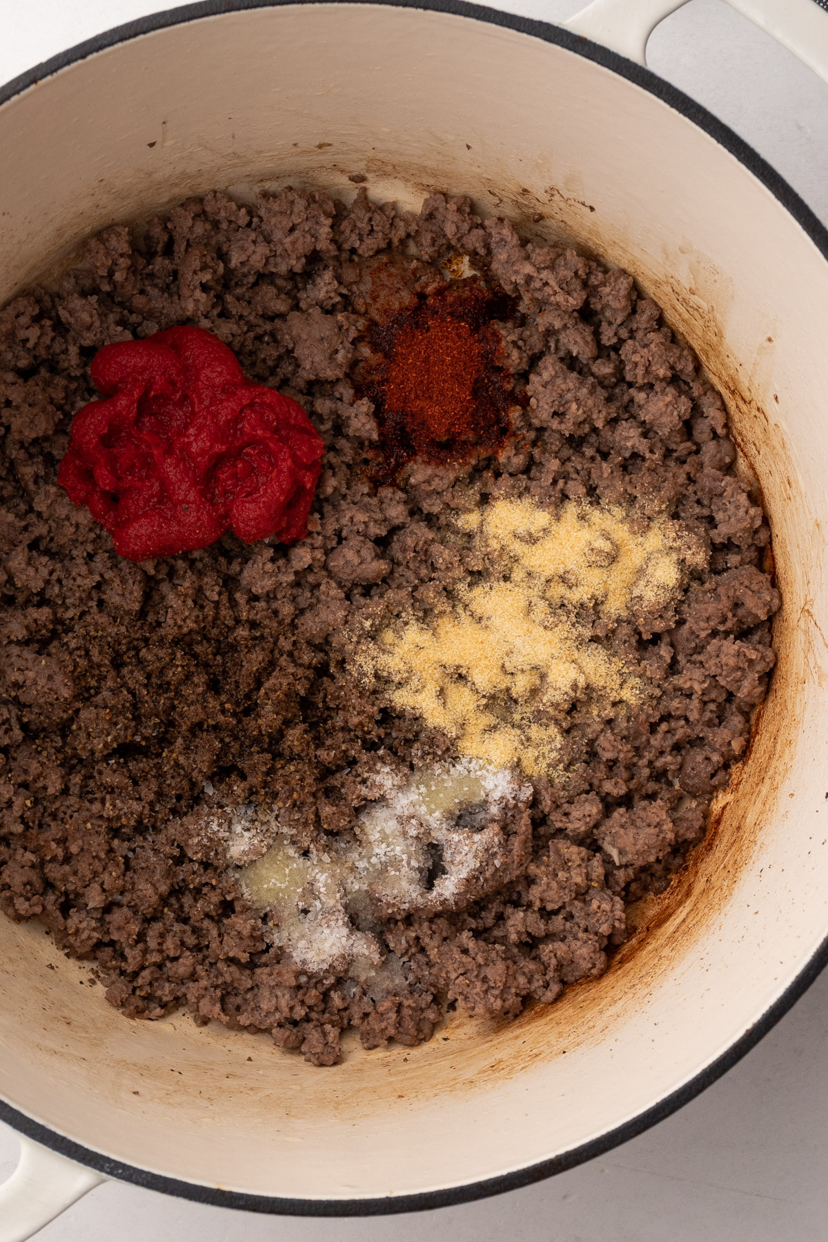 Cooking the ground beef, tomato paste and spices in a large pot.