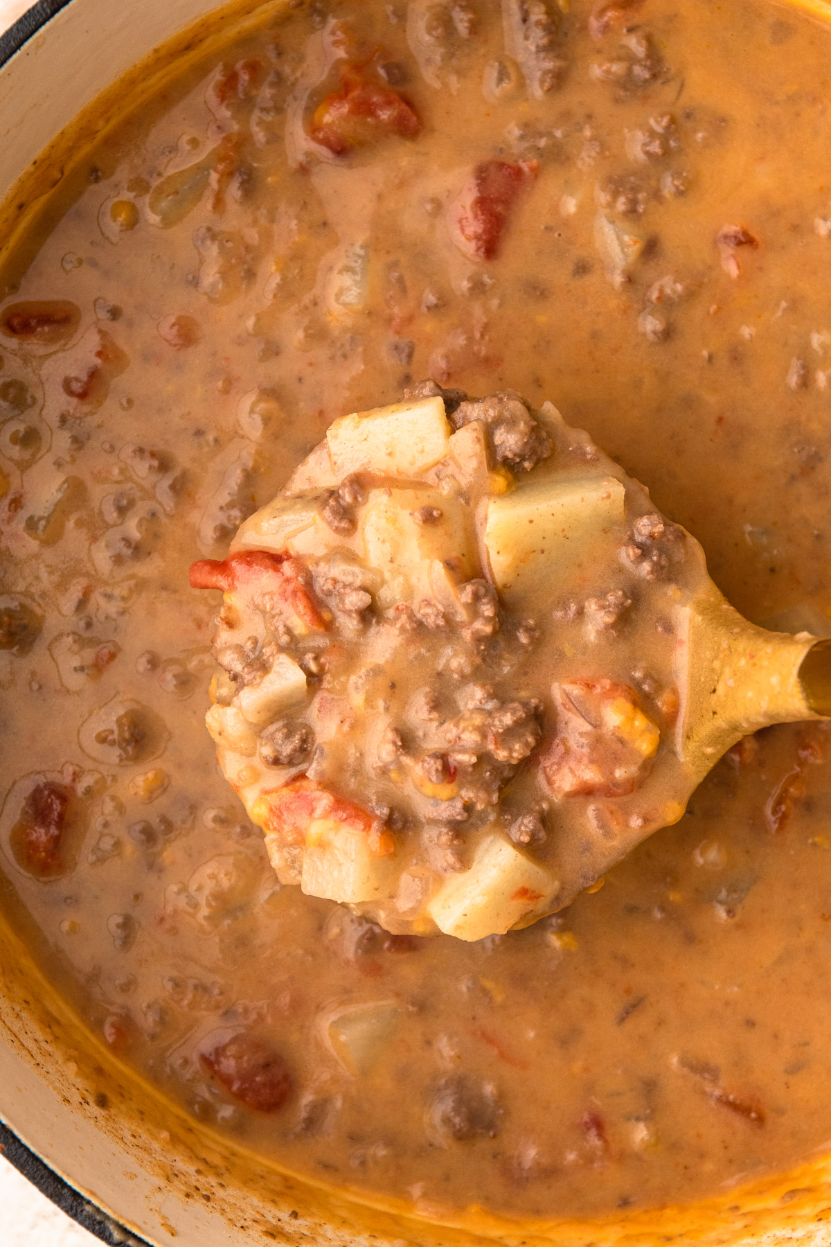 Cheeseburger soup in a ladle.