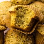 A from scratch pistachio muffin with a bite taken from it.