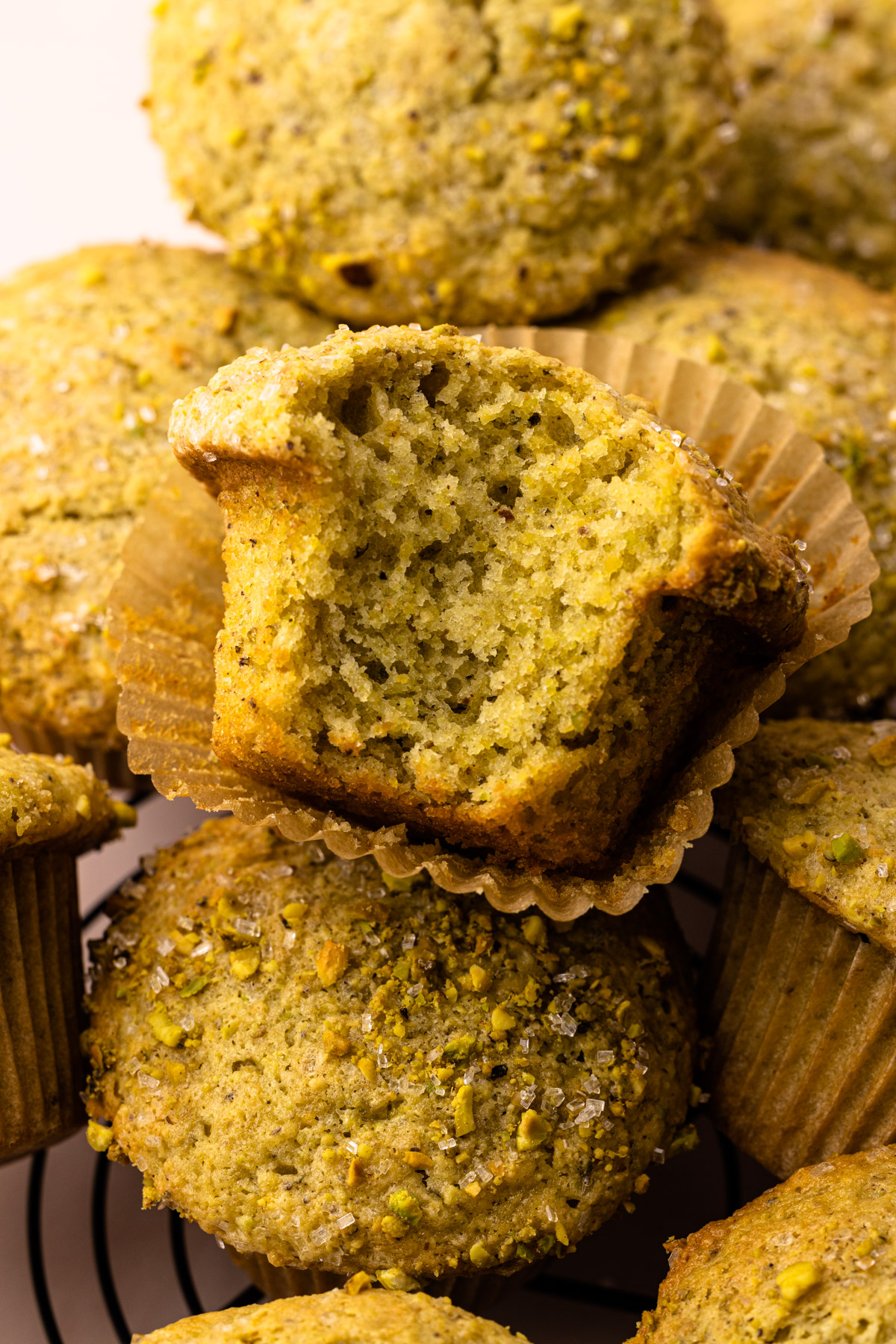 A from scratch pistachio muffin with a bite taken from it.