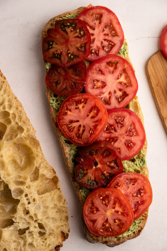 Making a blt with avocado sandwich.