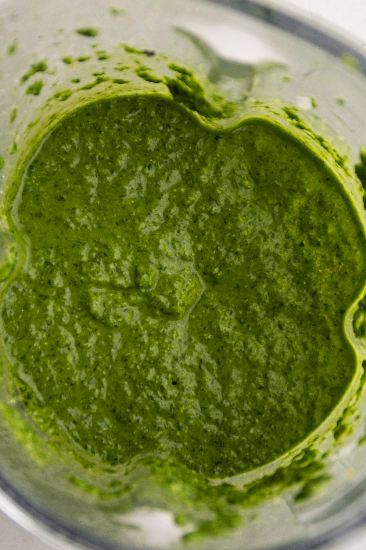 Bright green spinach basil pesto in a blender.