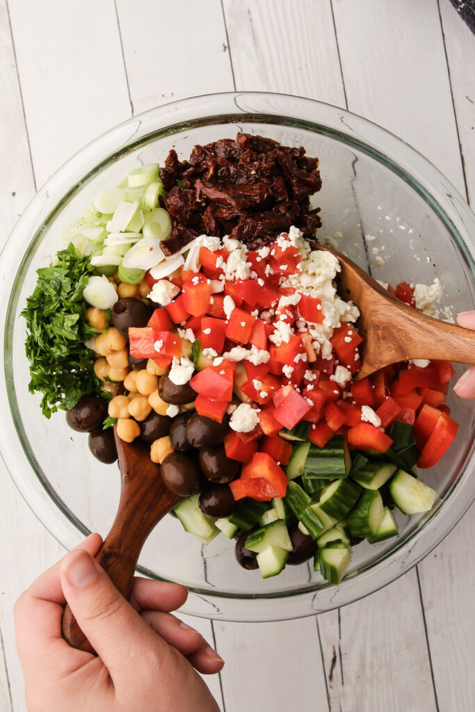 Chickpea salad getting mixed together in a bowl.