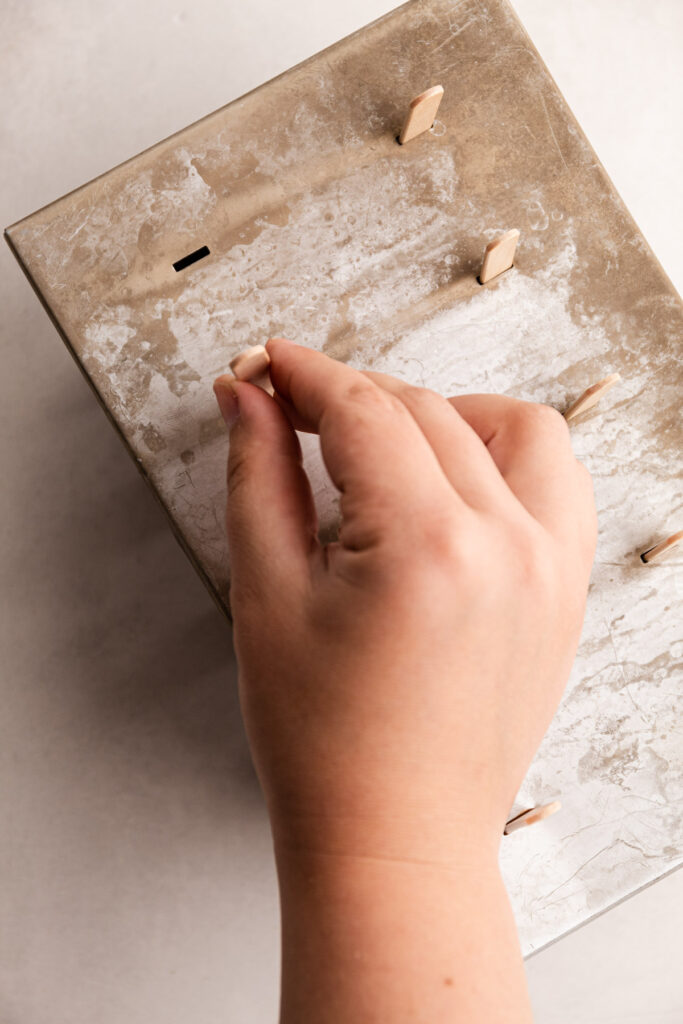 Putting popsicle sticks in a popsicle mold.