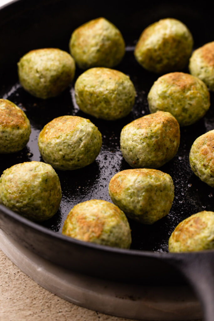 Pesto chicken meatballs on a baking tray.