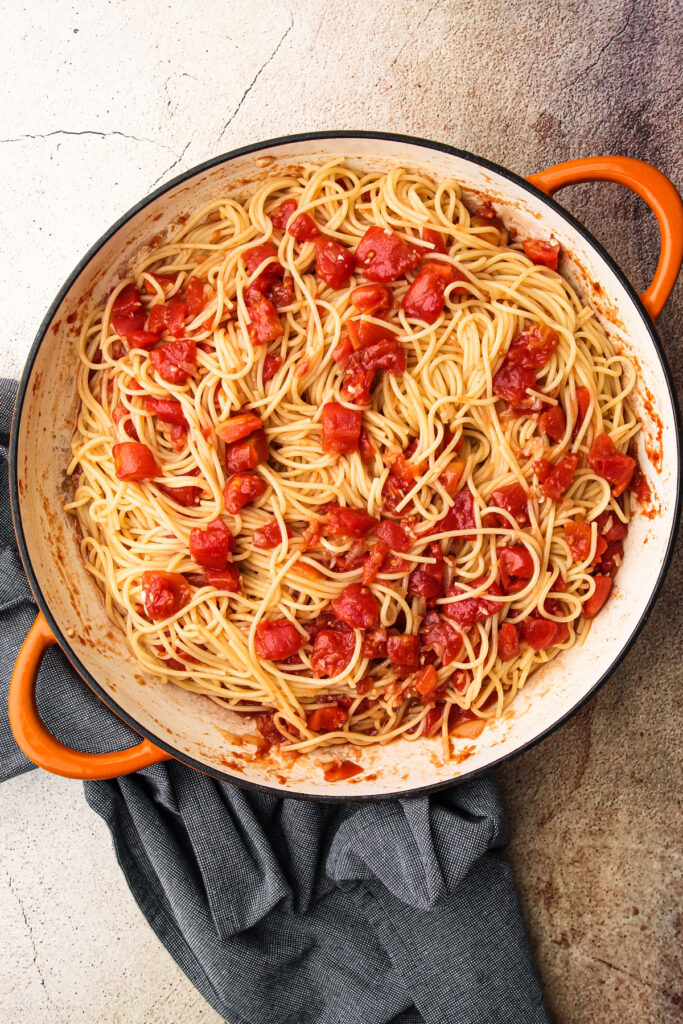 Pasta and tomatoes in a skillet.