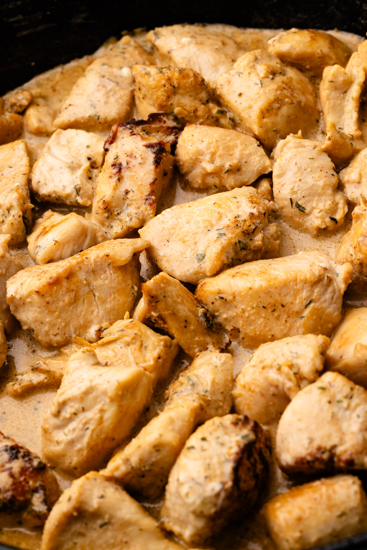 Ranch chicken bites in a cast iron skillet with a creamy sauce.