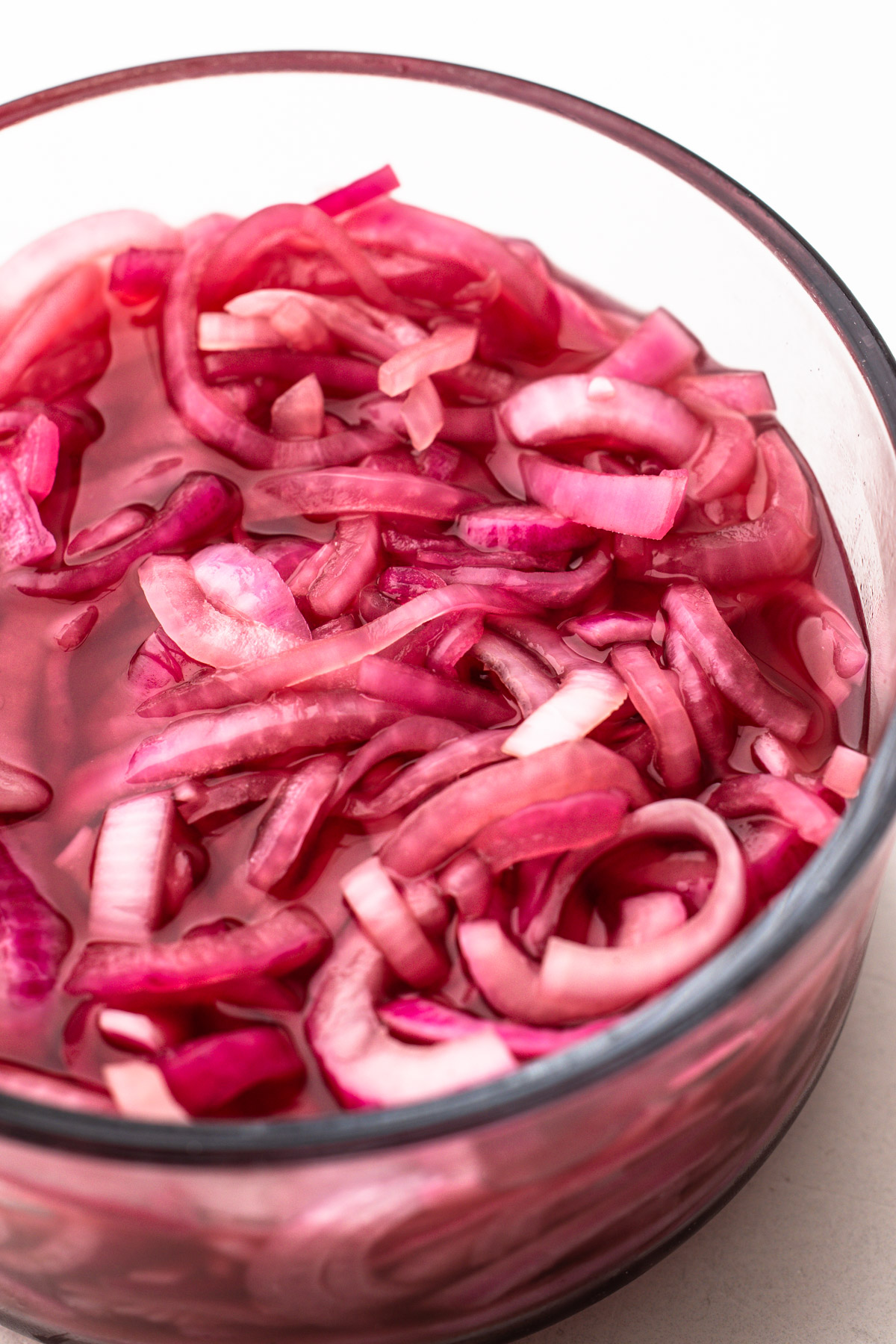 Quick pickled red onions in a container.