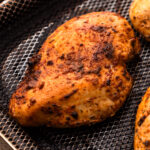 A cooked air fryer chicken breasts with spices.