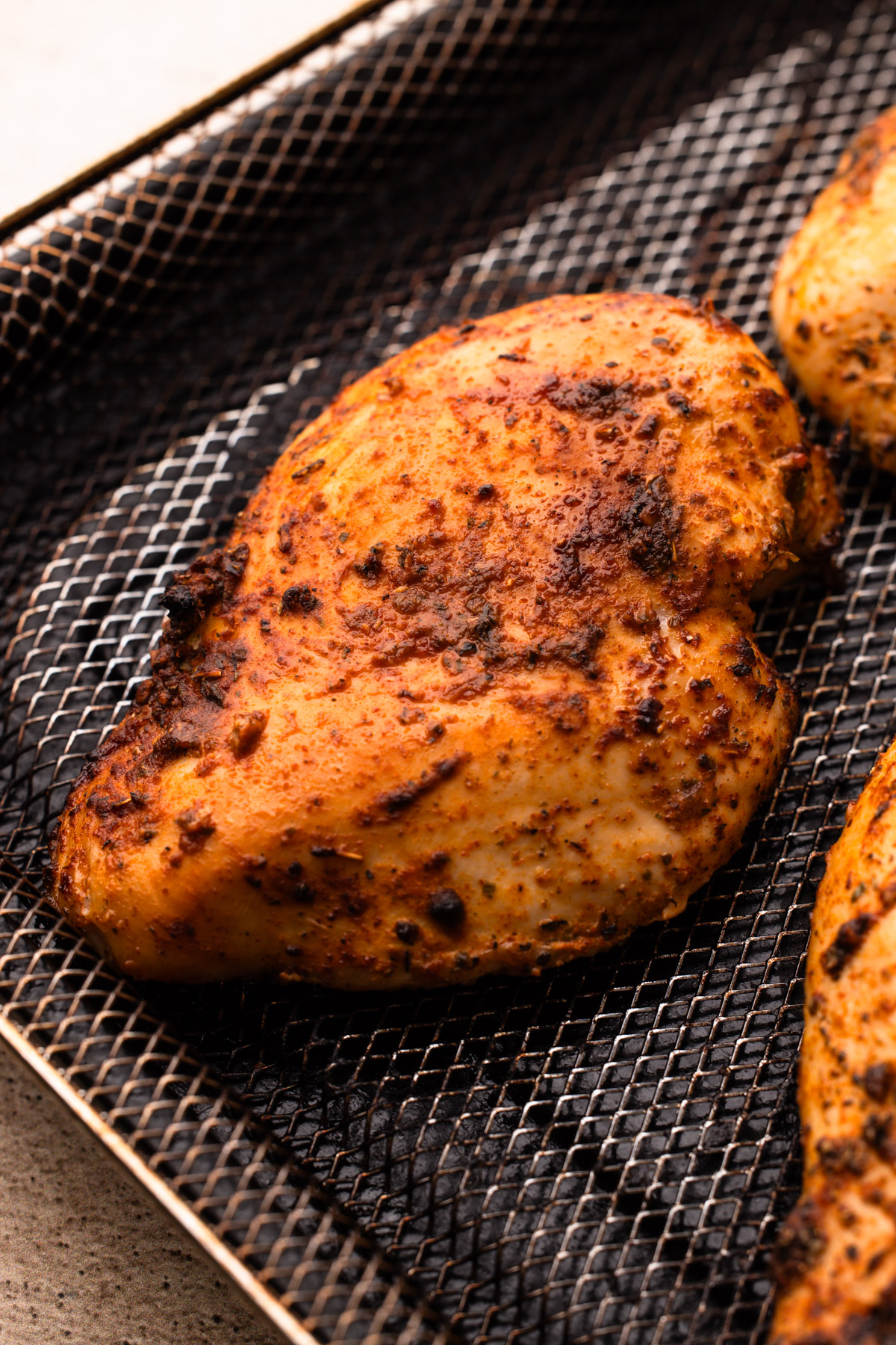 A cooked air fryer chicken breasts with spices.