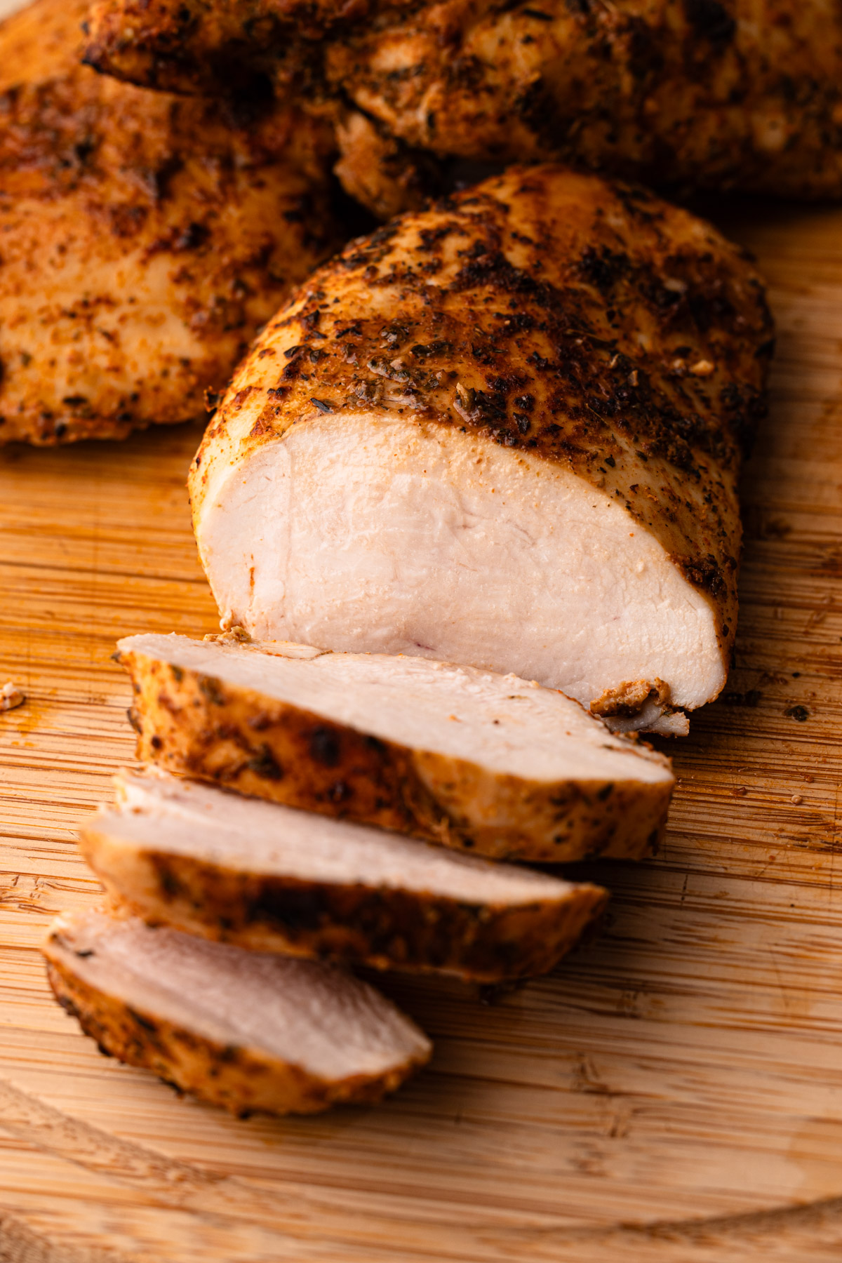 A close up of a perfectly cooked air fryer chicken breasts that has been sliced.