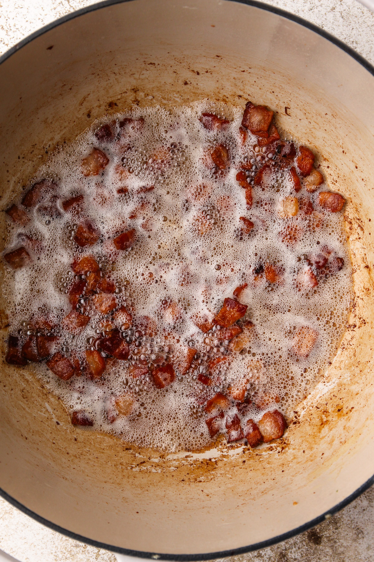 Bacon cooking in a dutch oven.