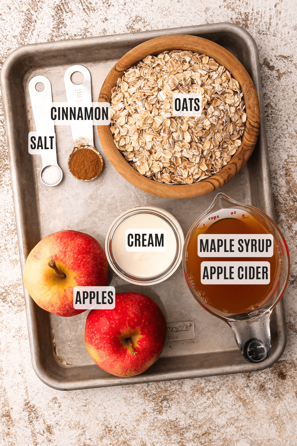 Ingredients for apple cinnamon oatmeal measured out on a tray.