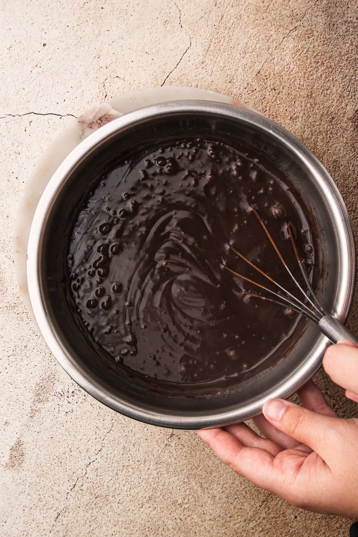 A hand whisking together pudding.