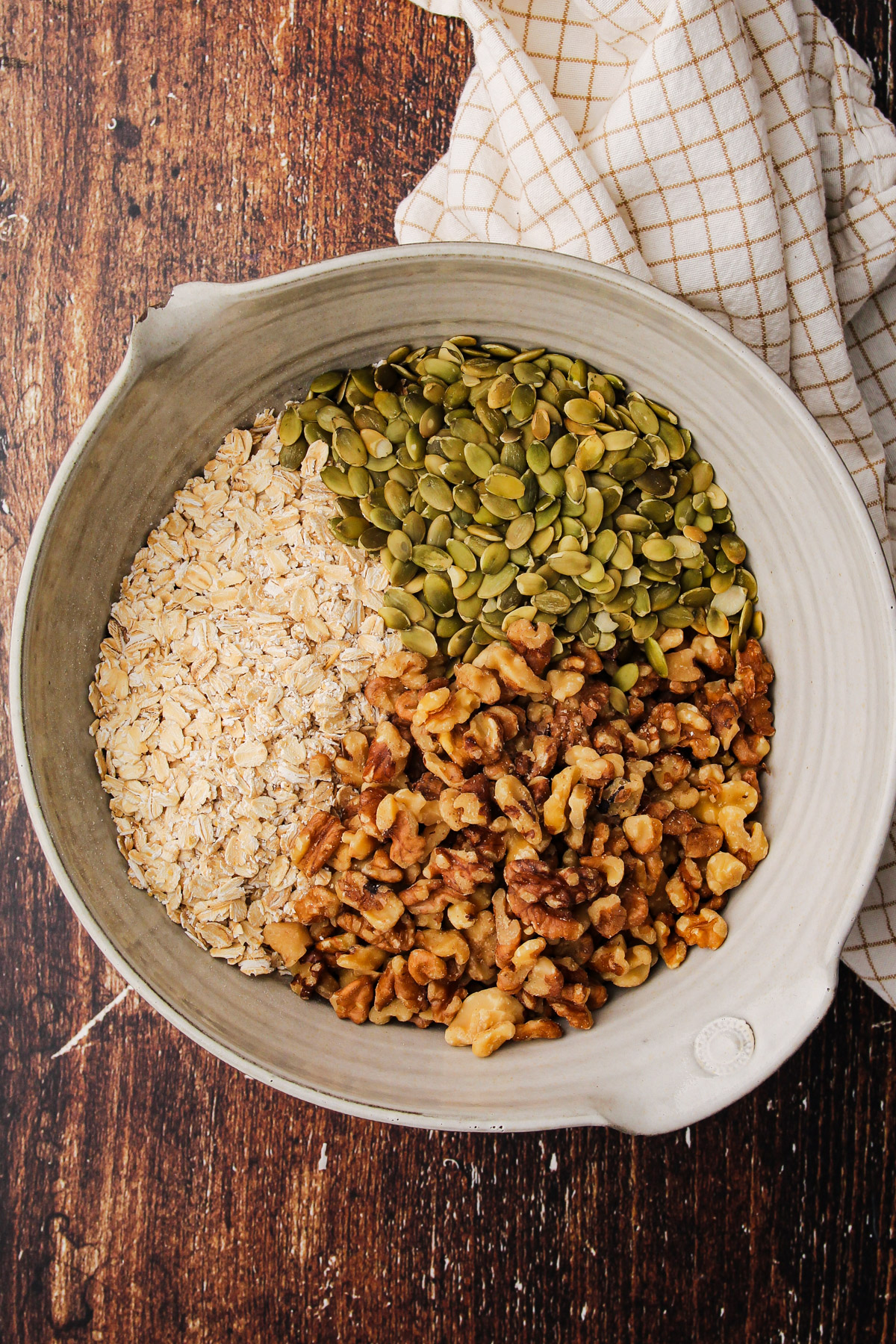 A bowl with dry ingredients for maple walnut granola.