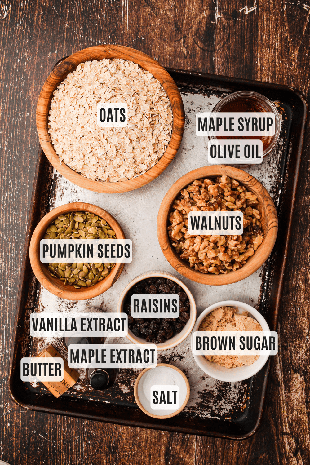The ingredients for maple walnut granola measured out and arranged on a baking sheet.