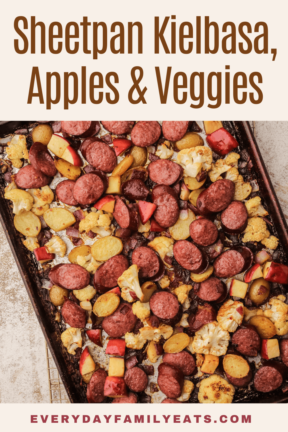 A sheetpan of roasted kielbasa, vegetables, and apples.