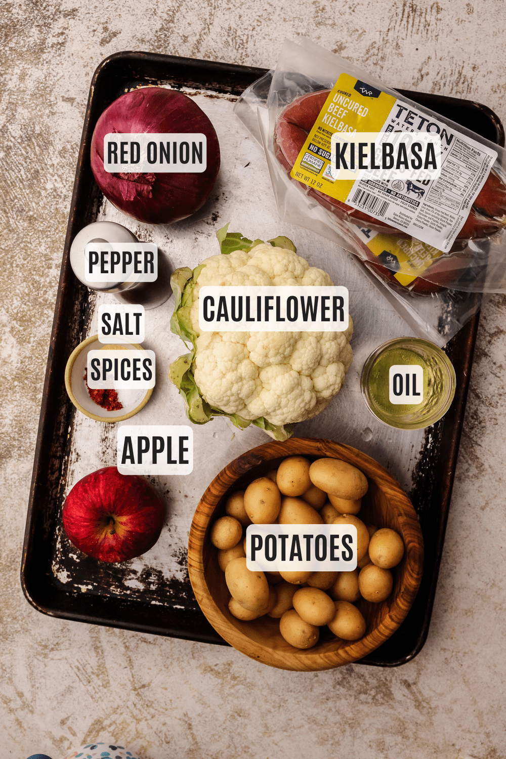 The ingredients for sheetpan kielbasa measured out and arranged on a baking sheet.