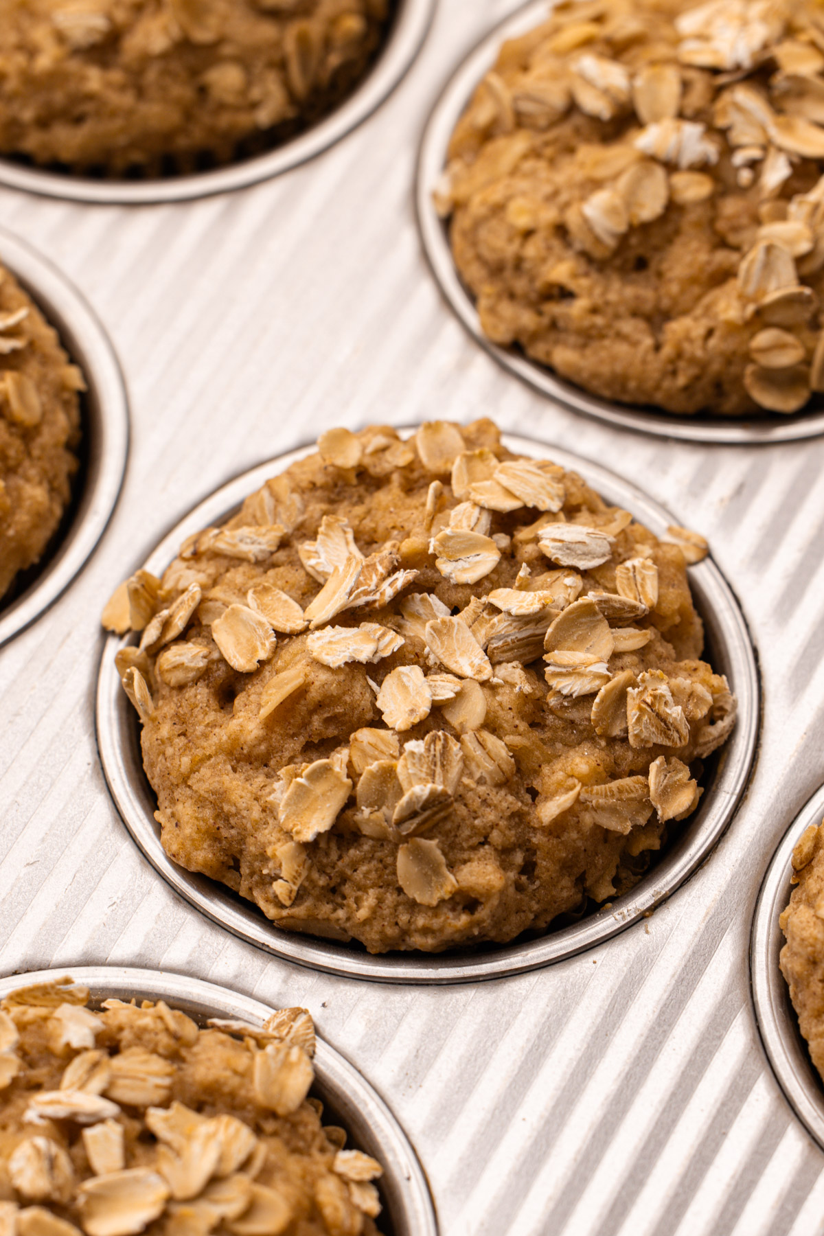 Baked wholesome apple muffins in a metal muffin tin.