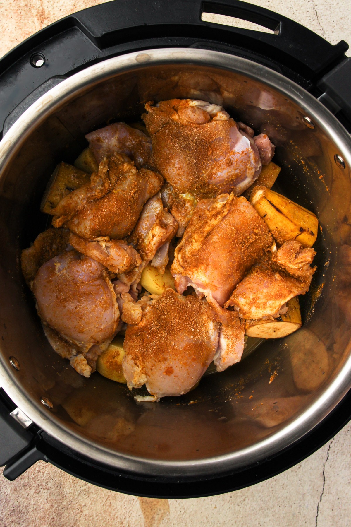 Uncooked colombian chicken stew in a pressure cooker.