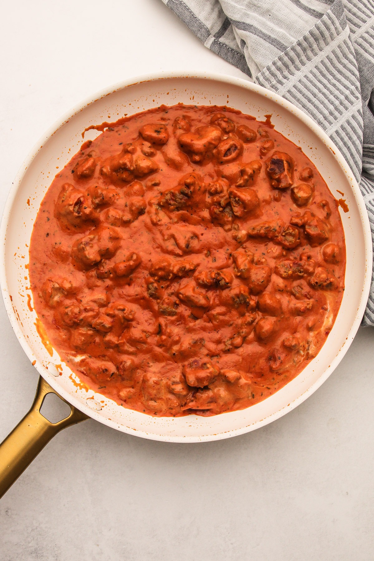 Sauce in a skillet for creamy tomato tortellini with sausage.