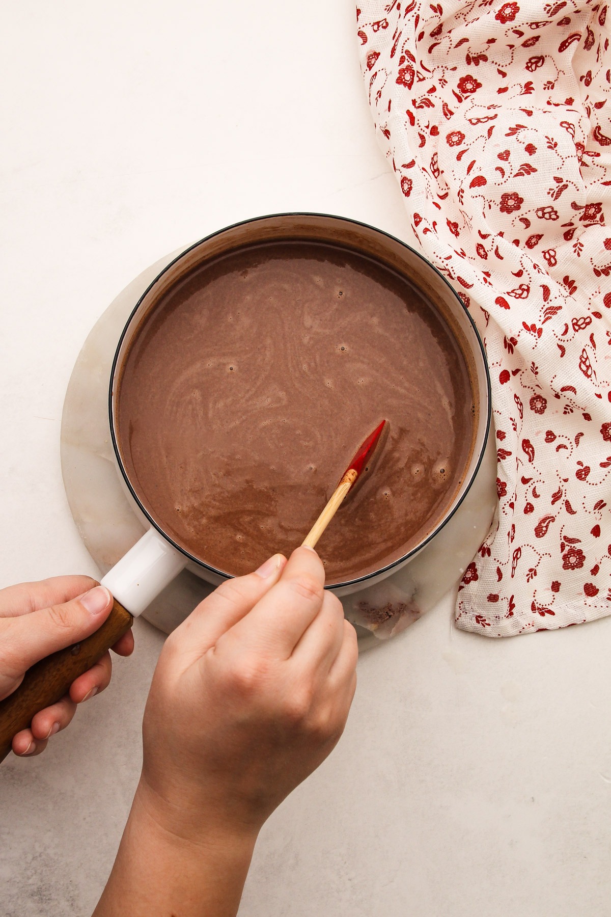 Stirring together chocolate chips and milk to make an easy hot chocolate recipe.