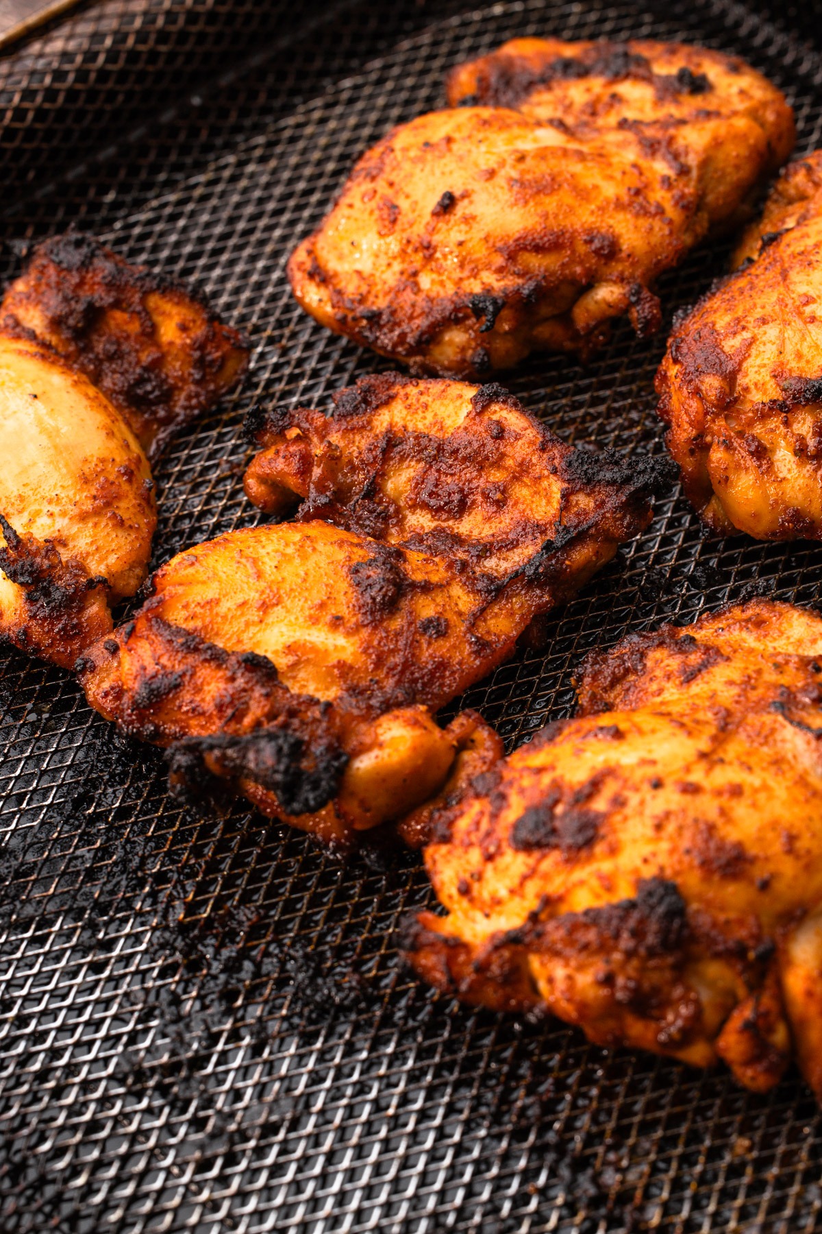 Cooked air fryer chicken thighs in an air fryer basket.