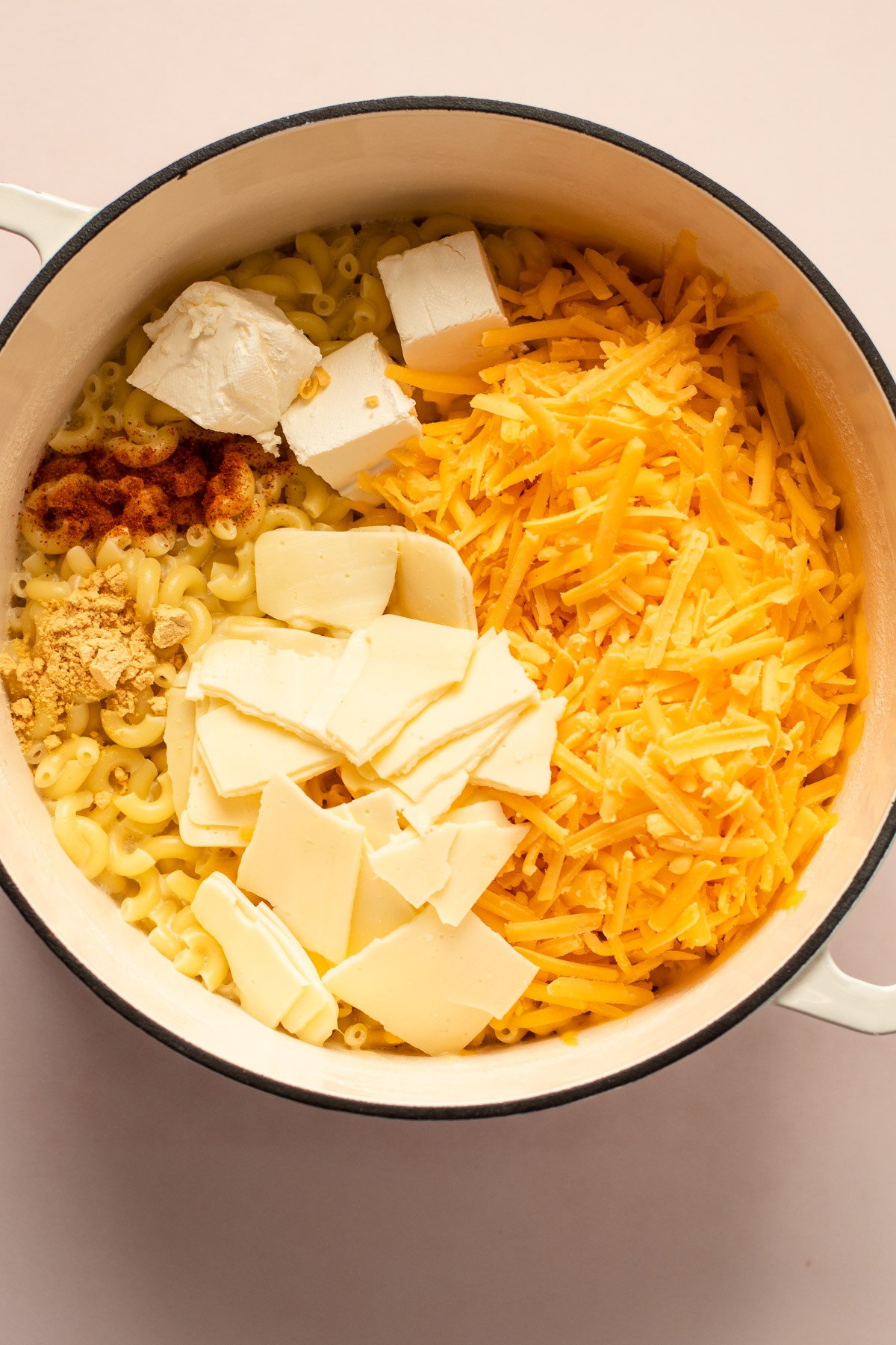 A white pot with ingredients for stovetop mac and cheese in it.