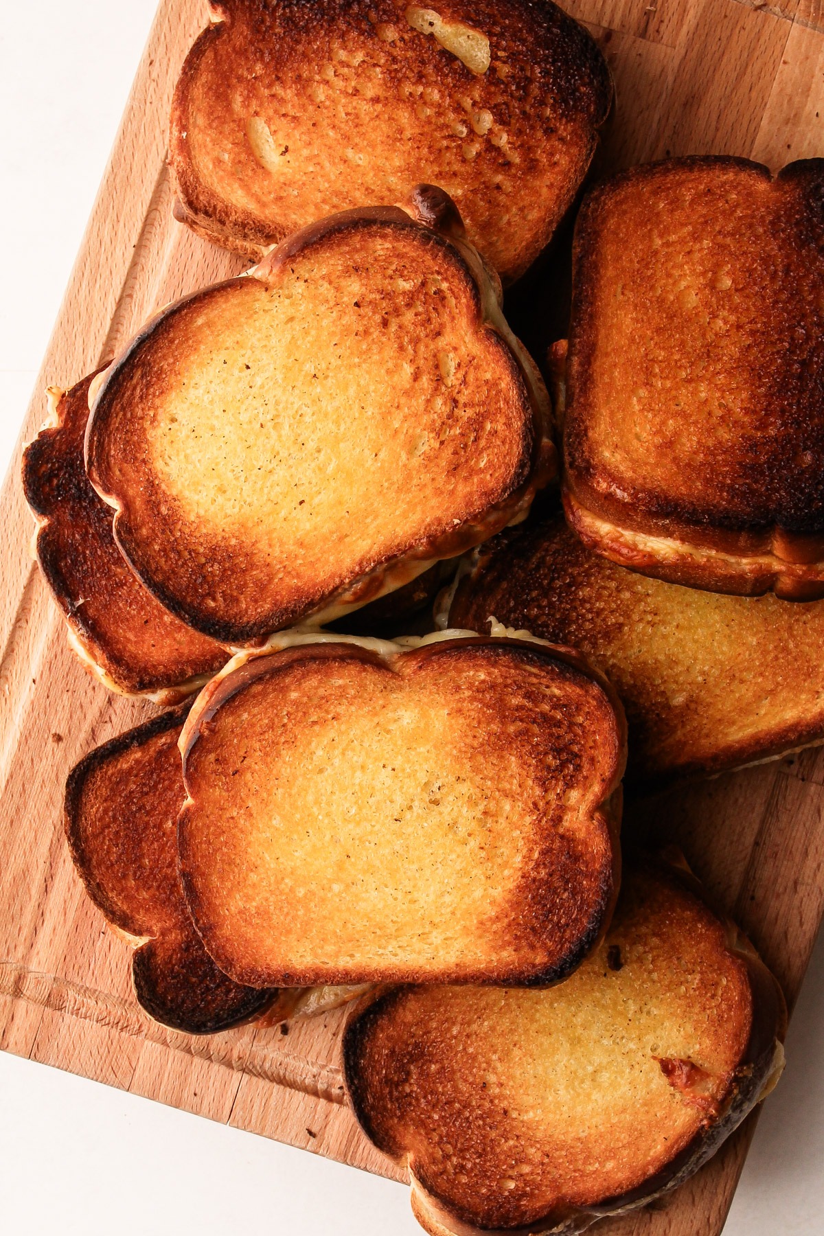 Many air fryer grilled cheese sandwiches on a cutting board.