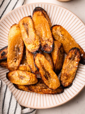 Air fried plantains plated with a sprinkle of salt.